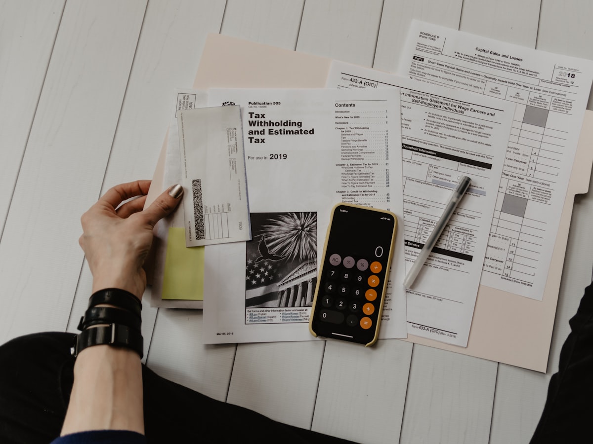 Escritorio con documentos, calculadora y bolígrafo para hacer cálculos